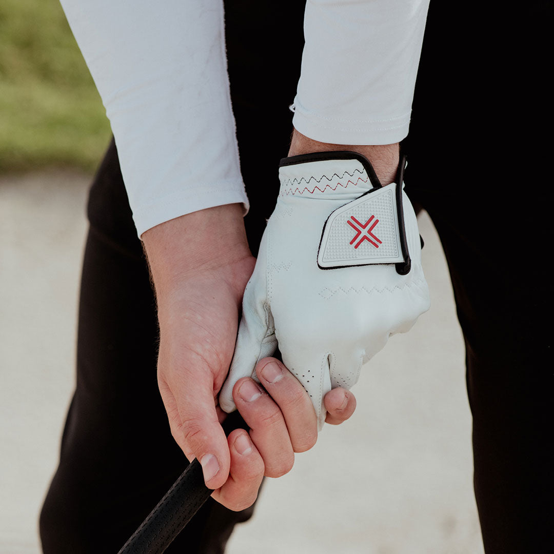 Golfer holding a golf club wearing the PAYNTR X Glove